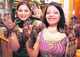 Girls show designs of mehndi on their palms ahead of Karva Chauth in Ludhiana. 