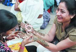 A vendor applies henna on the hands of a woman on the eve of Karva Chauth in New Delhi