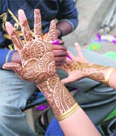 MEHNDI PATTERNS: A woman gets mehndi applied to her hands on the eve of Karva Chauth in Karnal on Thursday. 