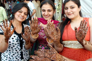 Preparing for fast: Women get mehndi applied on their hands at Model Town in Jalandhar on Thursday.