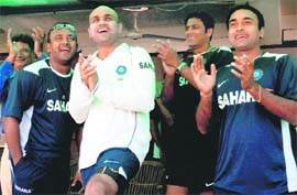 Well done, mate: Virender Sehwag (L), Anil Kumble (C) and Amit Mishra applaud after Sachin Tendulkar surpassed Brian Laras record of maximum runs in Test cricket at PCA stadium in Mohali on Friday.