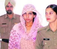 Babita, who is accused of murdering four children, in custody of the police in Gurgaon on Saturday.