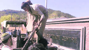 Labourers unload material to be used for construction at the cross-LoC terminal at Rangarh nullah on the Poonch- Surankote road in Poonch district.