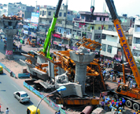 Workers clear debris of the under-construciton Delhi Metro Rail Corporation (DMRC) bridge that collapsed yesterday morning at Vikas Marg in East Delhi.