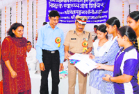 Rohtak range IGP distributes prizes among outstanding students at a medical check-up camp at Saini Girls School in Rohtak recently.
