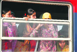 Ecstatic girls peep through a window of Kashmir's first-ever train between Budgam and Anantnag in Srinagar on Monday.