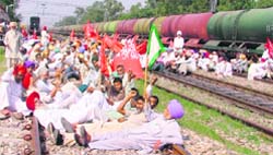 Farmers block the track at the Ladhowal railway station, near Ludhiana