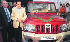 Mahindra and Mahindra chairman Keshub Mahindra (L) poses with petroleum minister Murli Deora (second from left) in front of a Mahindra Micro Hybrid Utility vehicle in New Delhi on Tuesday.
