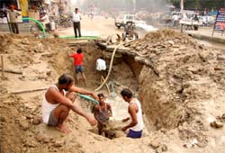 Labourers of water supply department digging up a trench to repair the leakage in the water pipe at Amreek Singh road in Bathinda