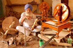 Sant Singh, a carpenter, busy in making a charkha (spinning wheel) at his work station in Jodhpur Pakhar in Bathinda