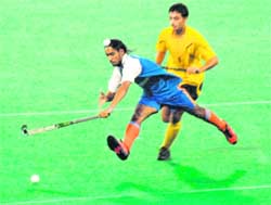 Captain of Surjit Hockey Academy jumps to get the ball in his possession during a match against Punjab and Sindh Bank Academy on Tuesday.