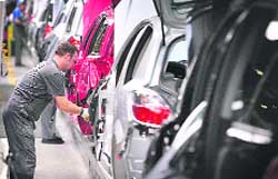 This file photo shows an employee of German car maker Opel working on the assembling of an Astra car at the Opel plant in Bochum, western Germany. US auto giant General Motors, owner of the German brand Opel, might extend work suspensions to all its European plants for several weeks, a press report said on Wednesday. 