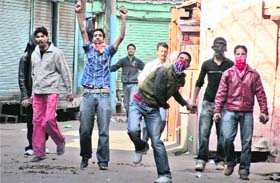 Youths pelt stones at policemen during a protest after the arrest of JKLF chief Yaseen Malik at Maisuma in Srinagar