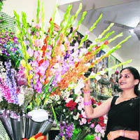 A woman takes a look at artificial flowers at a store in Ludhiana.