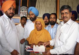 Sarup Chand Singla, area in-charge of the SAD (B), distributing cheques of Shagun scheme at his office in Bathinda on Friday.