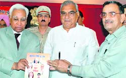 Haryana Governor A.R. Kidwai (left) releases a book on Chief Minister Bhupinder Singh Hooda at Raj Bhawan