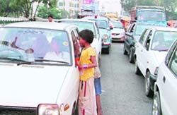 Beggars hound cars at a traffic junction in Ludhiana