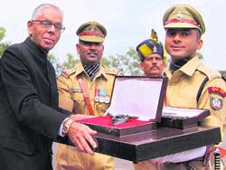 National security adviser M.K. Narayanan presents The Prime Ministers Baton and Home Ministrys Revolver for the best all-rounder Probationer to Divya Mishra, Parade Commander at the 60th Batch of IPS Probationers, in Hyderabad 