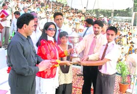 Haryana minister of state for sports and youth welfare Kiran Choudhry presents a trophy to a student during the annual function of the Motilal Nehru School of Sports, Rai, Sonepat