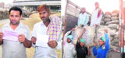 Truck drivers show papers of rejected paddy and a truck being unloaded at the grain market in Ludhiana