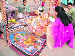 A woman buys a picture of Lakshmi and Ganesha for Diwali.