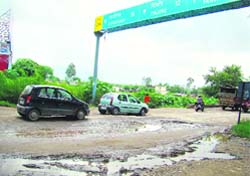 Crater-shaped pothloes like this dot roads in Baddi