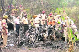 Police personnel inspect the site of plane crash in Jugiana village near Ludhiana on Wednesday.