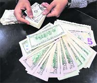 A Sri Lankan foreign exchange dealer displays US dollar bills at a currency exchange office in Colombo on Thursday. Sri Lanka's Central Bank announced it would allow its rupee greater exchange rate "flexibility" to make its exports more competitive. There were no immediate transactions in the rupee that was trading at 108 to the US dollar prior to the bank's morning announcement.