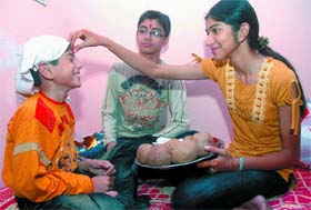 A girl puts tilak on her brother's forehead on the occasion of Bhai Dooj in the Capital