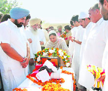 Dr Upinderjit Kaur, Punjab minister for education and civil aviation, places a wreath on the body of pilot Manjit Singh Khokhar on behalf of the Punjab government at Ratia on Thursday. Khokhars father, Baba Buta Singh (with white flowing beard), is also seen in the picture.
