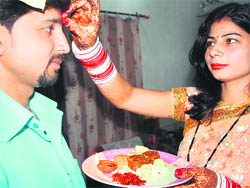 A woman applies tilak on the forehead of her brother on the occasion of Bhaiya Dooj in Jammu on Thursday.