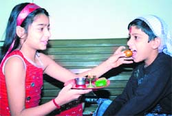A sister offers sweets to her brother on the occasion of Bhaiyya Dooj in Ludhiana 
