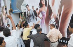 Activists of the Rashtriya Janata Dal remove posters of the film Fashion, as the film has been shot in Maharashtra