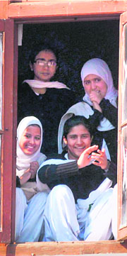 College girls watch the kho-kho match from their classroom window at Womens College in Srinagar on Saturday.