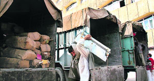 Labourers carry trunks with office records from the Srinagar civil secretariat on Satruday.