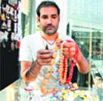 A shopkeeper prepares jewellery from beads