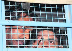 Injured prisoners talk to mediapersons from inside a police van in Bathinda 
