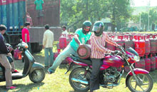 A person takes away an LPG cylinder purchased from the park of Sector 8 residential area in Chandigarh on Sunday.