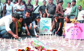 Assamese people stage a candlelight protest against the serial blasts in Assam, at Jantar Mantar in New Delhi on Sunday. 