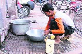 A boy washes utensils in Ludhiana