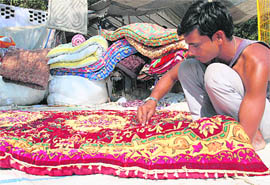 With the winter season round the corner, a man stitches quilt to eke out a livelihood in Phase-II, Mohali, on Monday.