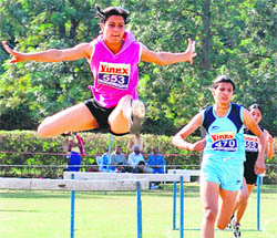 Players in action in 400m hurdle event during the Panjab University Inter-College Annual Athletics Meet held on PU grounds, Chandigarh, on Monday.