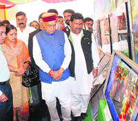 Chief Minister Prem Kumar Dhumal watches an exhibition at the Hamir Utsav in Hamirpur on Sunday night.