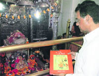 Novelist, art historian, poet and linguist Onkar Rahi offers his latest book on Paharai miniature painting at the Bajjreshwari temple at Kangra on Monday.