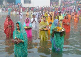 Devotees stand in water during Chhath puja celebrations in Gurgaon
