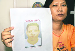 A police officer shows a sketch of a suspect involved in planting a car bomb, in Guwahati on Tuesday.
