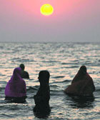 Devotees offer prayers on the beach during the Chhath Puja in Mumbai on Tuesday.
