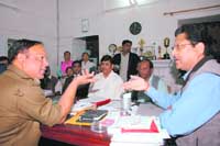 Congress leader Suryakant Dhasmana (R) talks to SSP Amit Kumar Sinha in Dehradun on Wednesday. 