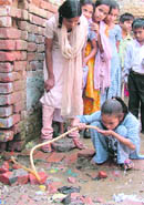 a child drinks water from a pipe