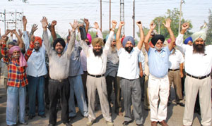 In support of their demands, employees of the PSEB staging dharna in front of the GNDTP gate in Bathinda on Thursday.